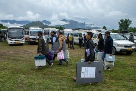 Commonwealth Round Table Research Article The greatest political show on earth: India’s general election 2024. photo shows Polling officers carrying Electronic Voting Machines (EVM) and Voter Verifiable Paper Audit Trail (VVPAT) machines.